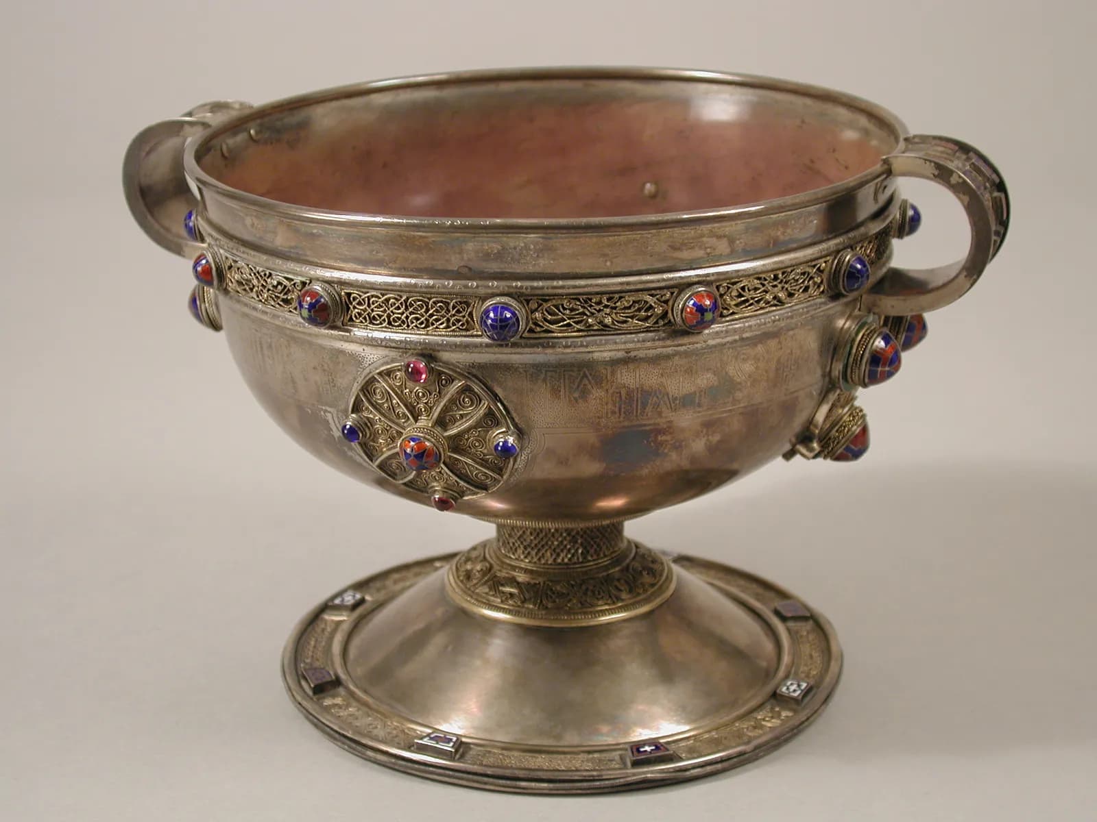 Cultural archive image of “The Ardagh Chalice”, catalogued as Irish, dating to early 20th century (original dated ca. 750). Medium: Silver, cooper alloy, enamel, glass.