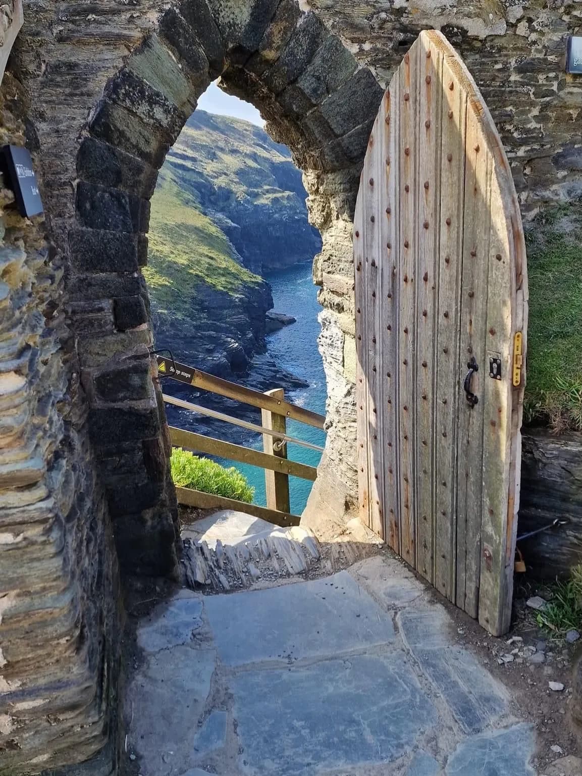 Cultural archive image of “Tintagel Castle sits on a dramatic clifftop headland on the north Cornwall coast, split…”, associated with Cornwall.