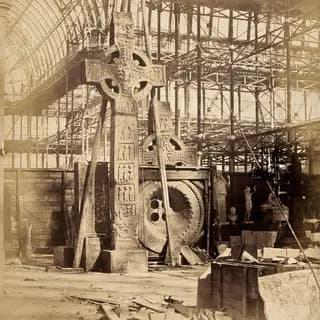 The Crystal Palace during its re-erection at Sydenham, London: a large celtic cross and other statues in the unfinished interior. Photograph by Philip Delamotte, ca. 1854.